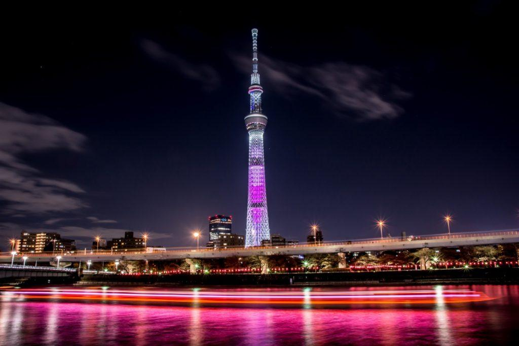 Tokyo Skytree stands next to the river reflecting its shadow on the surface